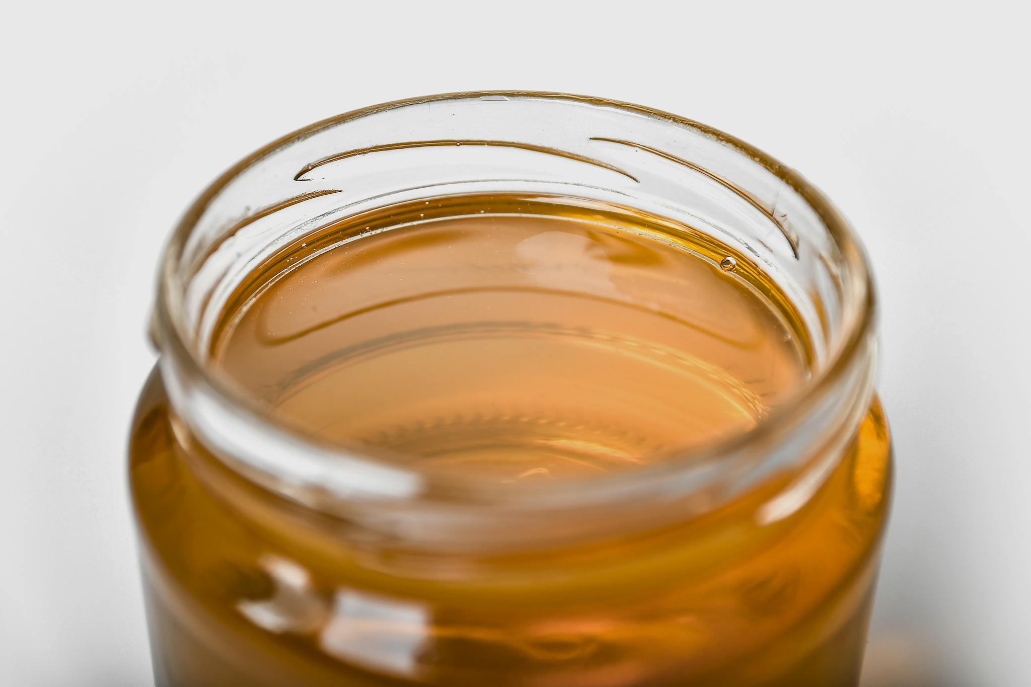 About 1 close up of a jar filled with golden