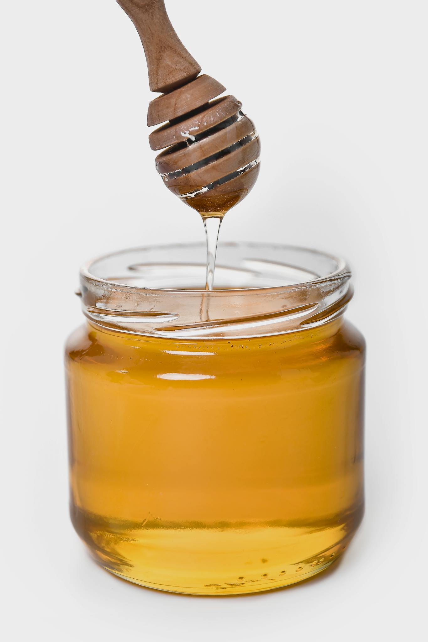 About 2 rich golden honey dripping from a wooden
